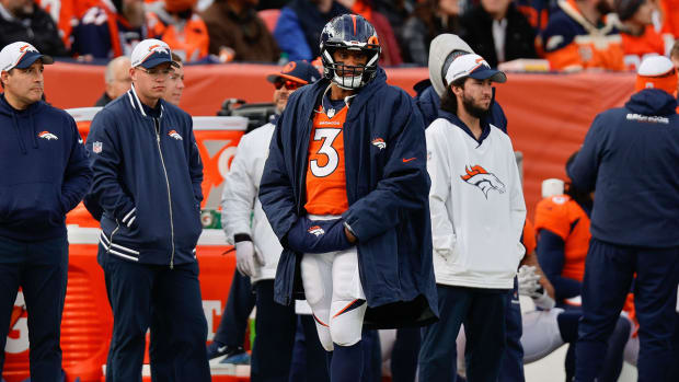 Russell Wilson wearing his helmet and a jacket on the Broncos sideline